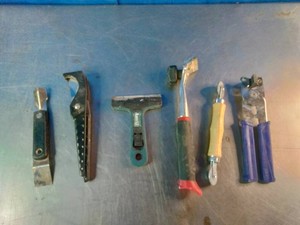 Six different hand tools, mostly scrapers and window-tinting or glass-cleaning implements.