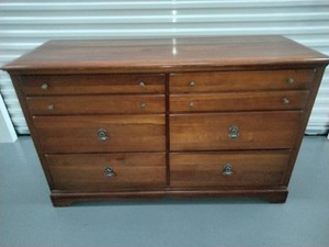 Solid wood double dresser with a warm reddish-brown finish and dual rows of drawers.
