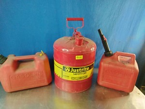 Justrite steel safety can flanked by two common red plastic gas containers