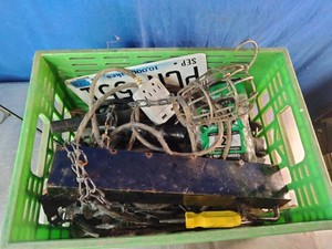 Green crate contains a mix of miscellaneous workshop items