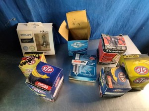 Storage tote filled with a collection of miscellaneous automotive parts, oil filers, light bulbs, cables, and more