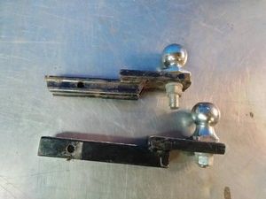 Two standard trailer hitch ball mounts with attached hitch balls,