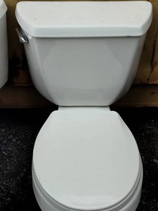 Standard white Kohler two-piece ceramic toilet with a rounded bowl