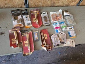 Lot of door hardware including decorative hinges, flush bolts, and cabinet latches
