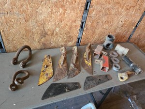 Miscellaneous Farm Equipment Parts including Blades, Shackles, Pipe Fittings, and Hose Components