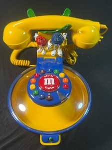M&M Candy Dish PhoneUntested, green handle the phone sits on has a broken off piece, button to open dish is broke but it still opens and stays shut