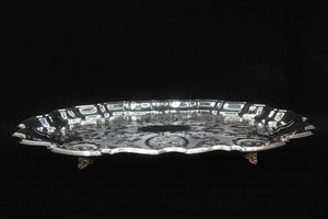 vintage footed oval serving tray with scalloped rim and intricate scrollwork in center