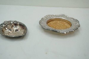 vintage wine bottle coaster with ornate embossed floral  and scroll rim with central protective cork, vintage heart shaped trinket or bon-bon dish