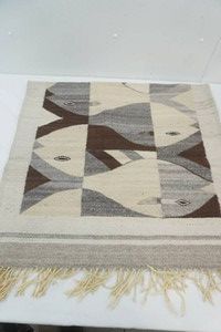 handwoven wool flat wear rug  featuring abstract fish tessellation pattern with fringe ends 30 x 60
