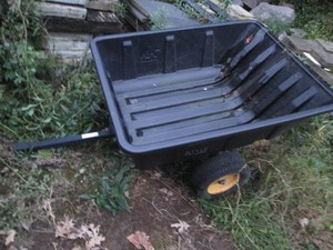 Pull behind yard trailer with wide tires and a plastic bed