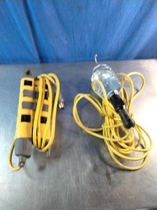 Multi-outlet power strip and a yellow-handled drop light or trouble light