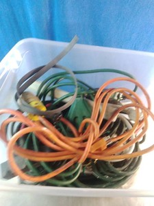 Plastic bin filled with various electrical extension cords