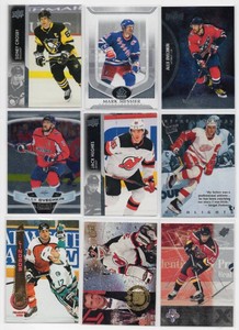 Lot of Nine Assorted Hockey Cards Including 2021-22 NHL Metal Universe Alex Ovechkin #125, 2021-22 Upper Deck Series 1 Jack Hughes #110, and More