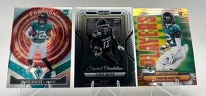 Lot of 3 Travis Hunter Rookie Cards Including 2025 Panini Phoenix Paragon RC #12, 2025 Panini Prizm Draft Picks Student Orientaion RC #7, and 2025 Topps Chrome Power Players RC #PP-29