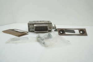 vintage automotive radio with knobs and mounting faceplate