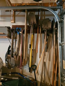 Various digging tools on wall in garage