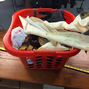 Laundry basket chock full of leather scraps used for craft projects
