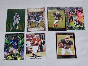 Lot of 7 Running Backs Football Cards Featuring Christian McCaffrey, Saquon Barkley, Marshawn Lynch RC, and Steven Jackson