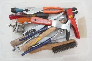 assortment of hand tools including pliers, wires brush, screw drivers, bike kick stand and more