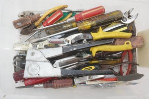 assortment of hand tools including pliers, wires brush, screw drivers, bike kick stand and more