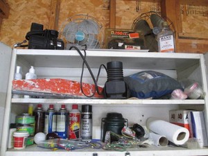 Content on and inside garage cabinet to include vintage desk fans, personal compressors, automotive chemicals and more