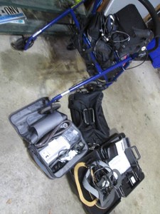 Portable walker with brakes and under seat storage plus variety of assorted medical supplies