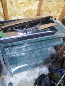 Metal storage shelf with lawn mower blades and other misc shown