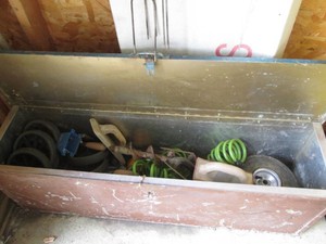 Metal covered footlocker tote containing a variety of masonry or drywall tools and more