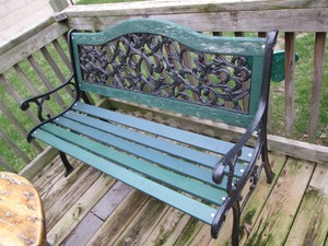 Wood slat park bench with decorative cast iron sides and back panel