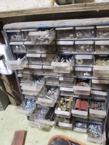 Multi-drawer organizer with a large variety of screws, nuts, bolts and other hardware