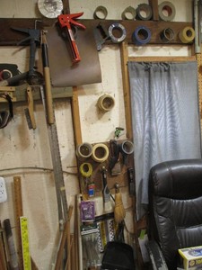 Variety of tape, wood dowels, caulking guns, paint brushes, hardware, and other supplies shown