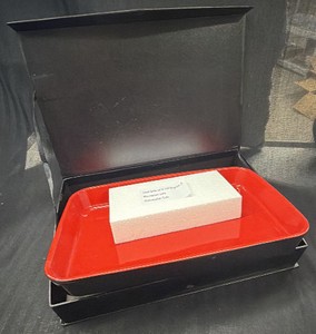 Brand New - This is a ceramic baking dish in a gift box a rectangular casserolelasagna-style pan with a glossy red interior and matte black exterior, packed in a black hinged presentation box.