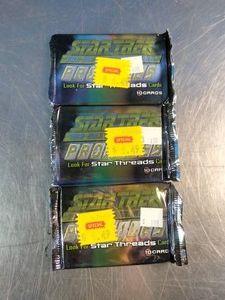 Three sealed foil booster packs of Star Trek The Next Generation Profiles trading cards