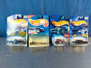 Four vintage, carded Hot Wheels die-cast toy cars from the 1990s and early 2000s
