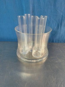A vintage 7-piece clear glass vodka shooter set, featuring six tall tube-style shot glasses inside a matching glass ice bucket or chiller.