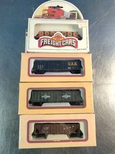 Vertical stack of four boxed HO scale model freight cars,
