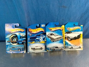 Four vintage 164 scale Hot Wheels die-cast cars in their original blue blister packaging