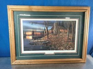 A framed art print Complete Serenity featuring a rustic lake cabin at sunset by wildlife artist Jim Hansel.