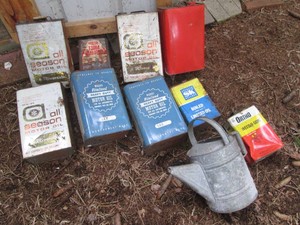 Collection of vintage motor oil and assorted chemical cans plus a metal watering can
