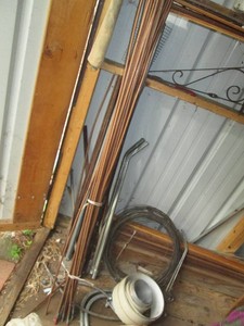 Variety of copper refrigeration line, rebar, megal tubing and other supplies shown