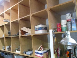 Big Money lot inside the cubby shelving to include vintage Torch, electrical wall plates, misc wire, mini blower motors, vintage barrel valves, garage chemicals and much more