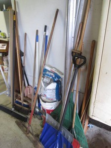 Collection of shop brooms, shovels, rake, yard markers, metal transition, ice melt and more