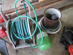 Sun-Cast garden hose reel with assorted hose, outdoor planter with drip trays and vintage freon can