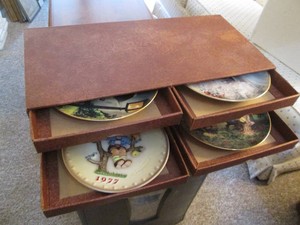 Collection of decorative display plates from Hummel in their own multi-drawer storage organizer