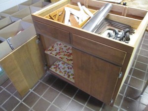 Cabinet with cupboard and drawers containing caster wheels, shelf brackets and more