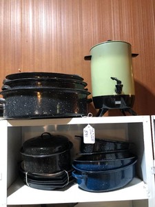 Roasters, coffee pot all on top of cabinet and top shelf
