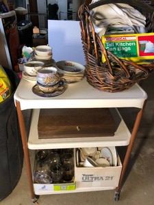 Metal cart with cup, saucers, clothes pins, basket