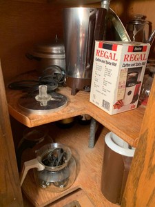 Coffee mill, coffee pots, pressure canner, Pyrex glass percolator jar and more all in corner lazy susan cupboard