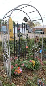 Metal garden arbor with extra metal pieces and bird feeders
