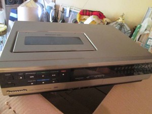 Vintage VHS movie player with small bundle of VHS tape movies